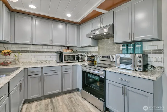a kitchen with stainless steel appliances granite countertop a sink stove and cabinets