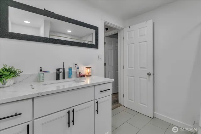 a hallway with sink and mirror