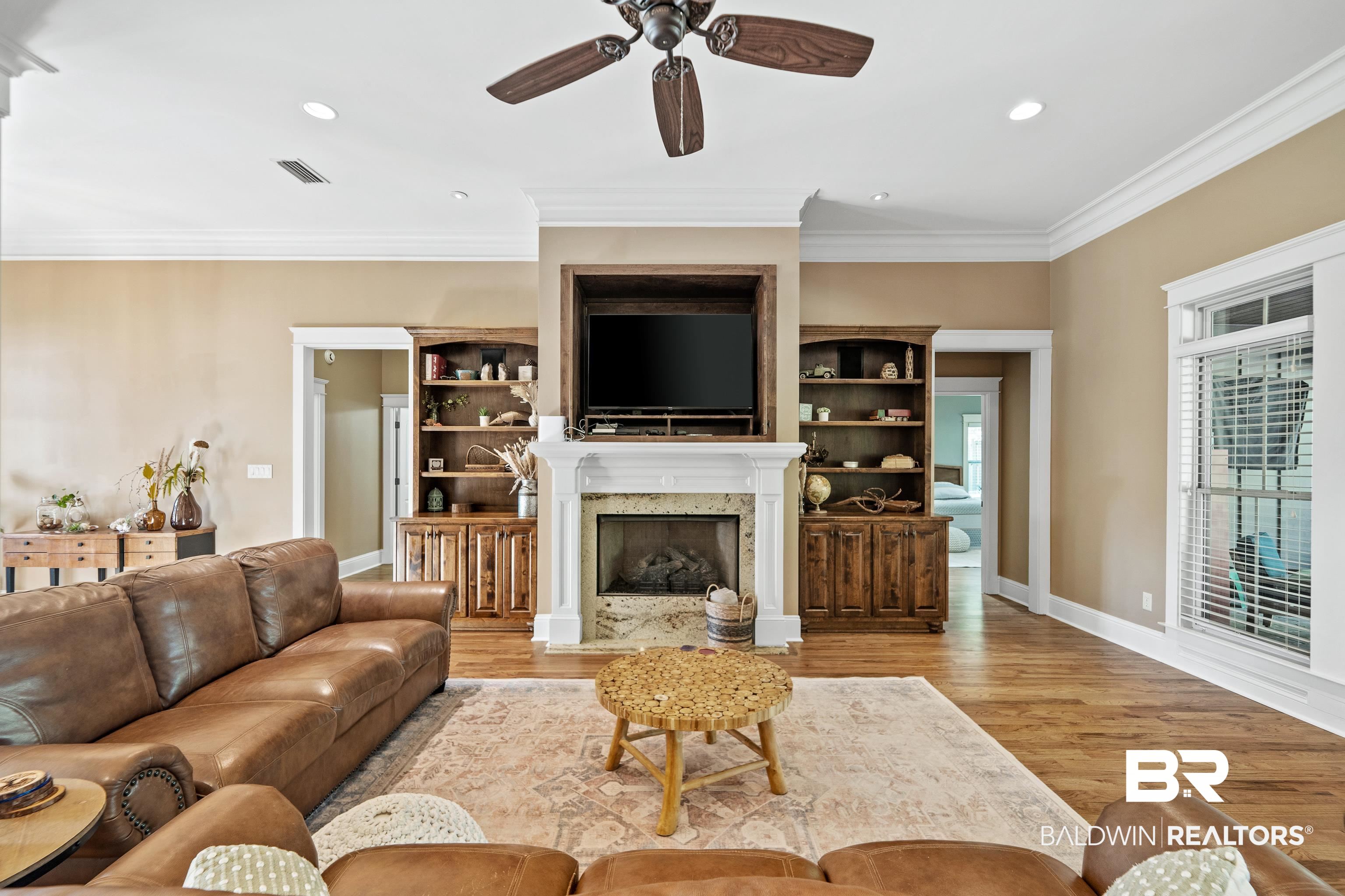 31829 Butler Drive Daphne, AL 36527 - Photo 11 of 48 Living room with ceiling fan, light hardwood / wood-style floors, a fireplace, and crown molding