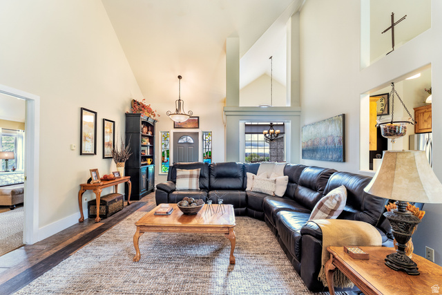7343 North Sawtooth Cv Road Vernal, UT 84078 - Photo 4 of 64 Spacious living area featuring vaulted ceilings, wood-finish flooring, and a large arched window with a chandelier