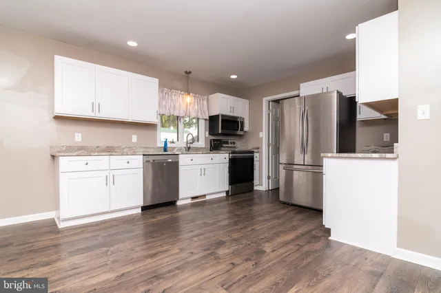 a kitchen with a refrigerator a sink and cabinets