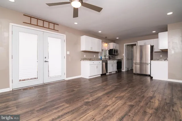 a view of a kitchen with a refrigerator and a stove top oven