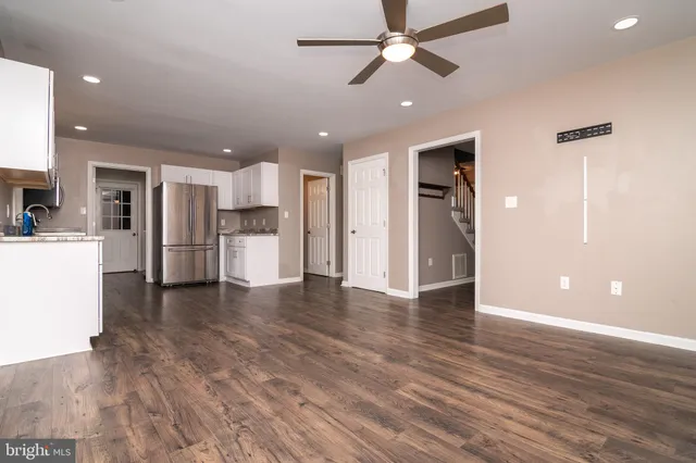 a view of a kitchen with a refrigerator and a stove top oven