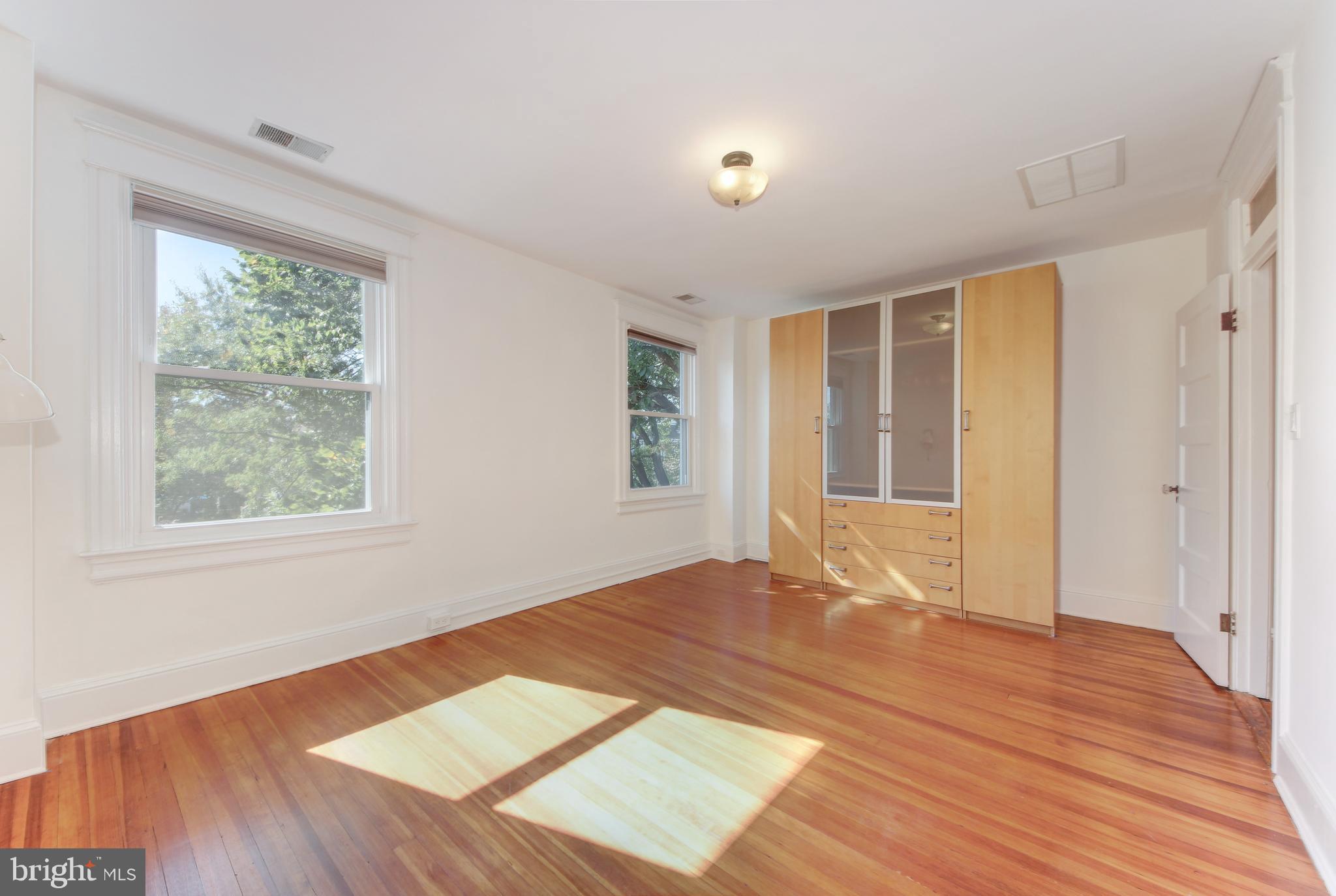 1321 Spring Road Northwest Washington, DC 20010 - Photo 11 of 30 a view of an empty room with wooden floor and a window