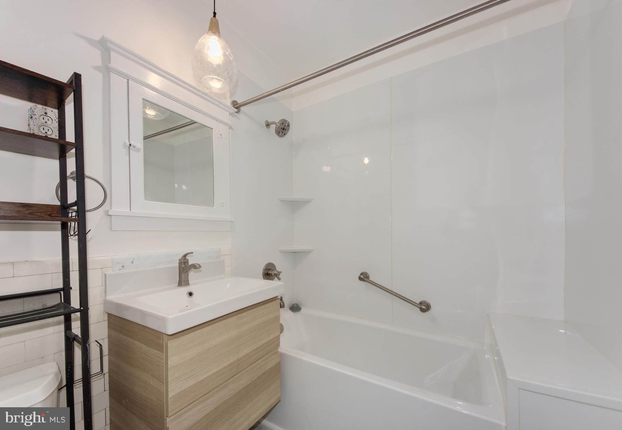 1321 Spring Road Northwest Washington, DC 20010 - Photo 13 of 30 a bathroom with a tub a sink and mirror