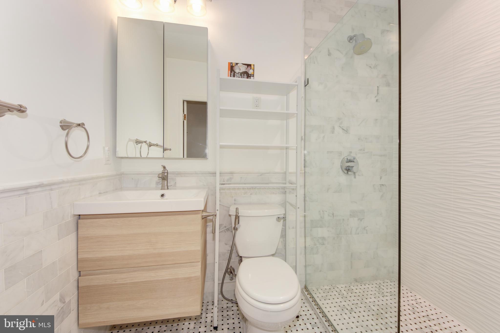 1321 Spring Road Northwest Washington, DC 20010 - Photo 14 of 30 a bathroom with a toilet a sink and shower