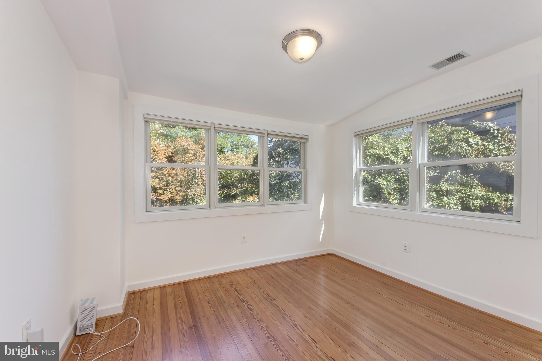 1321 Spring Road Northwest Washington, DC 20010 - Photo 17 of 30 an empty room with wooden floor and windows