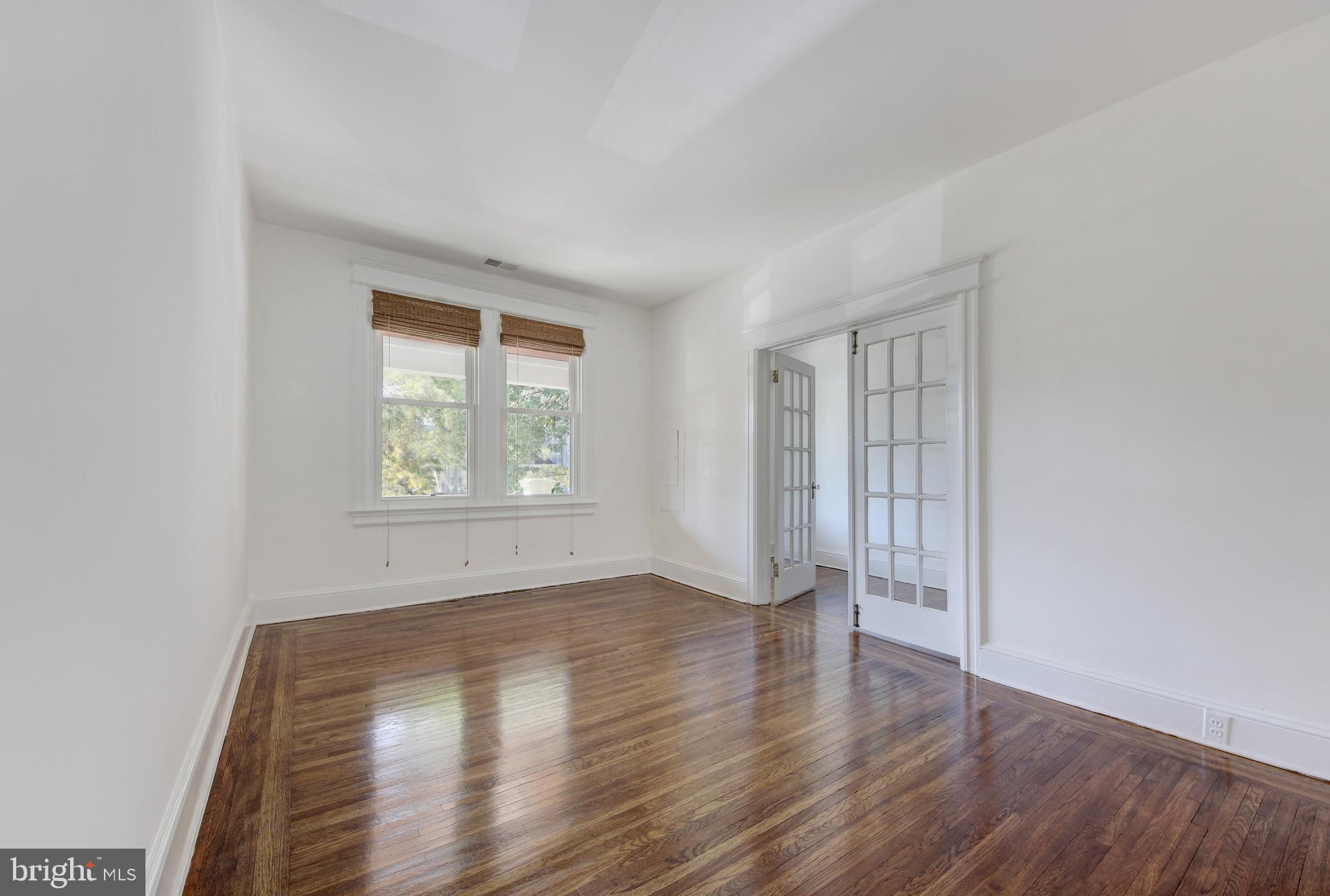 1321 Spring Road Northwest Washington, DC 20010 - Photo 4 of 30 an empty room with wooden floor and windows