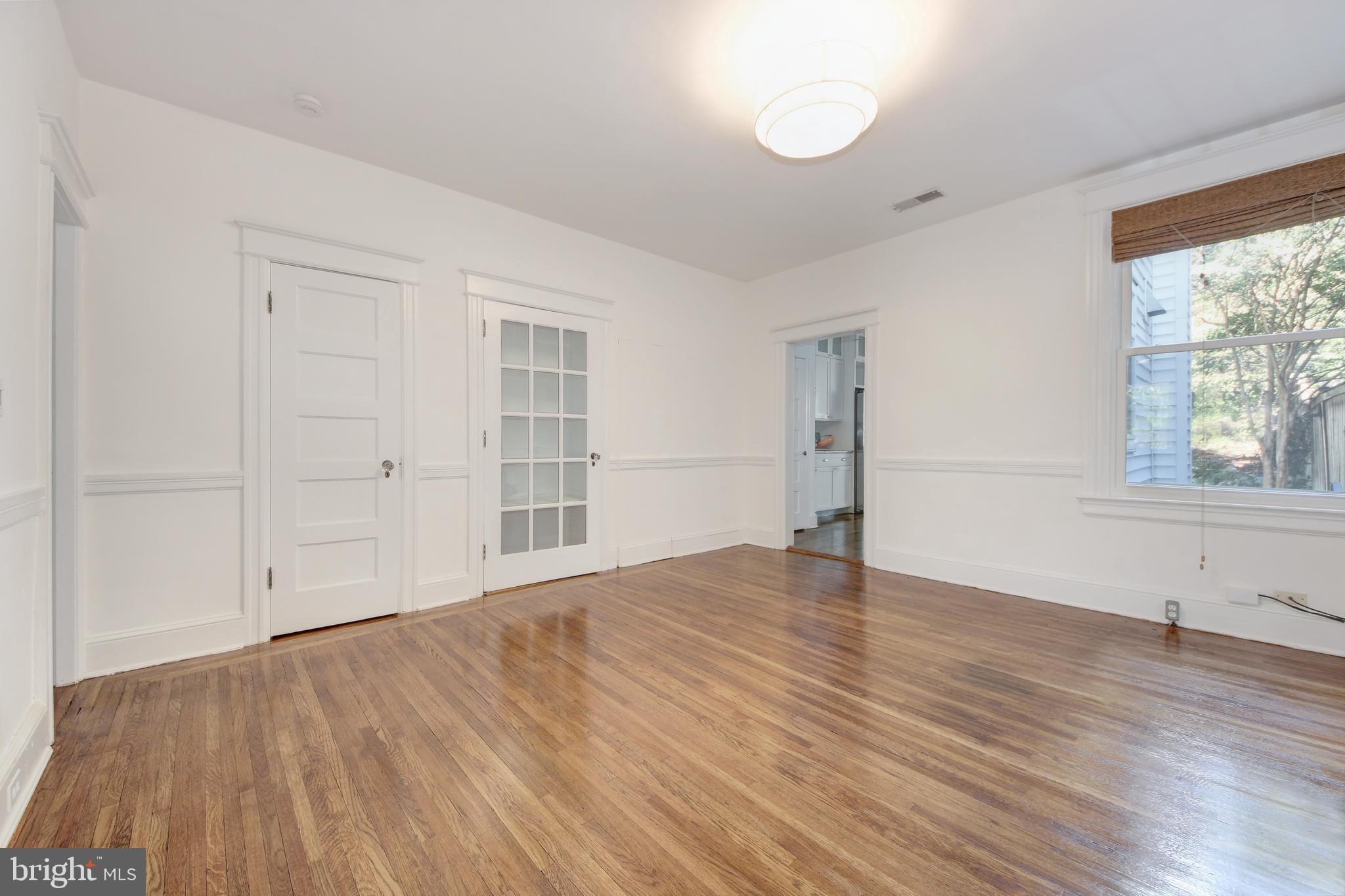 1321 Spring Road Northwest Washington, DC 20010 - Photo 6 of 30 an empty room with wooden floor and windows