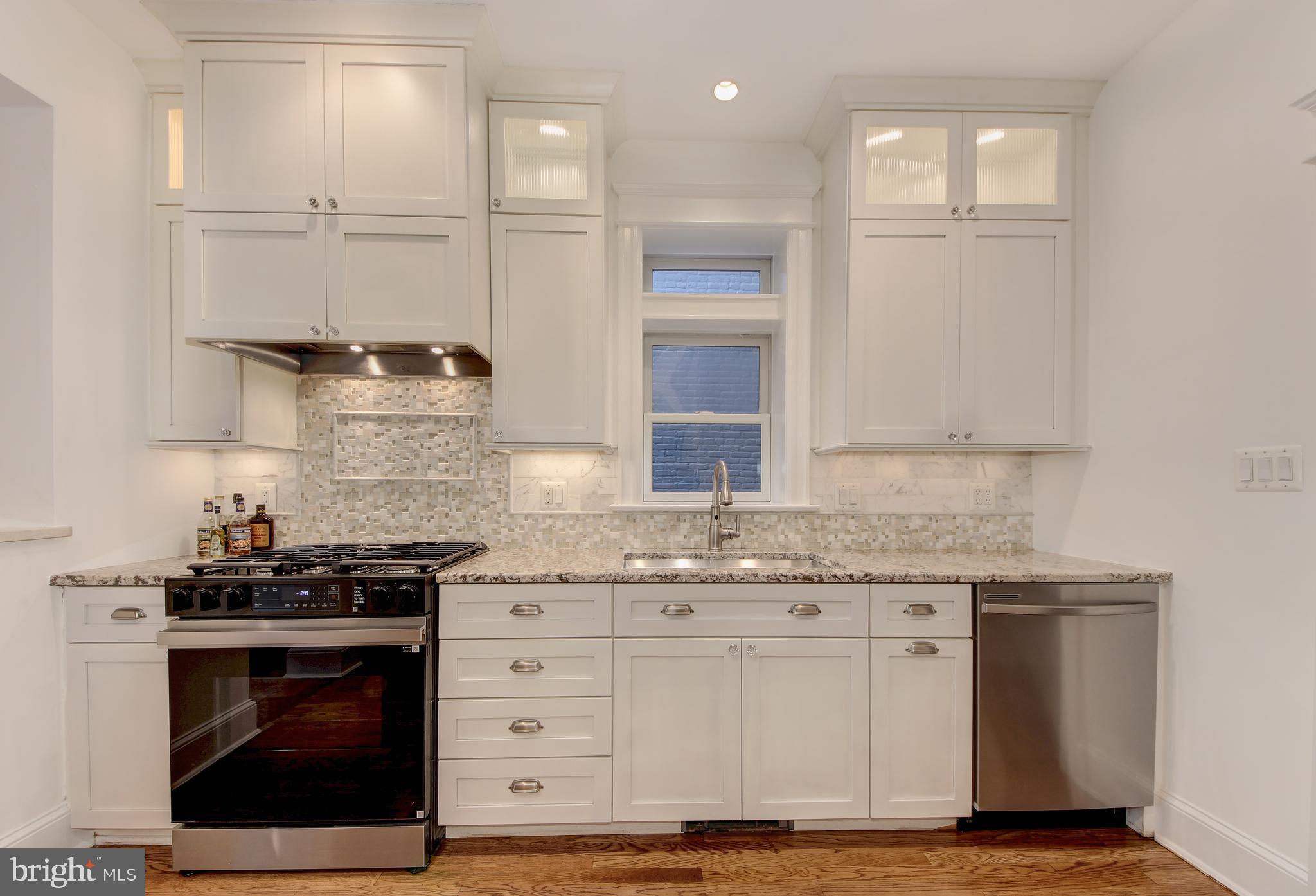 1321 Spring Road Northwest Washington, DC 20010 - Photo 9 of 30 a kitchen with granite countertop a stove a sink and a granite counter tops