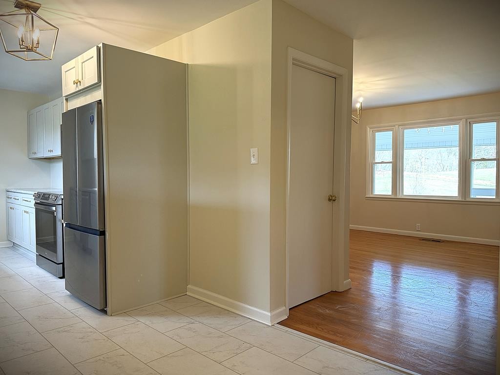 118 Collins Road Allons, TN 38541 - Photo 14 of 64 an empty room with wooden floor and a kitchen