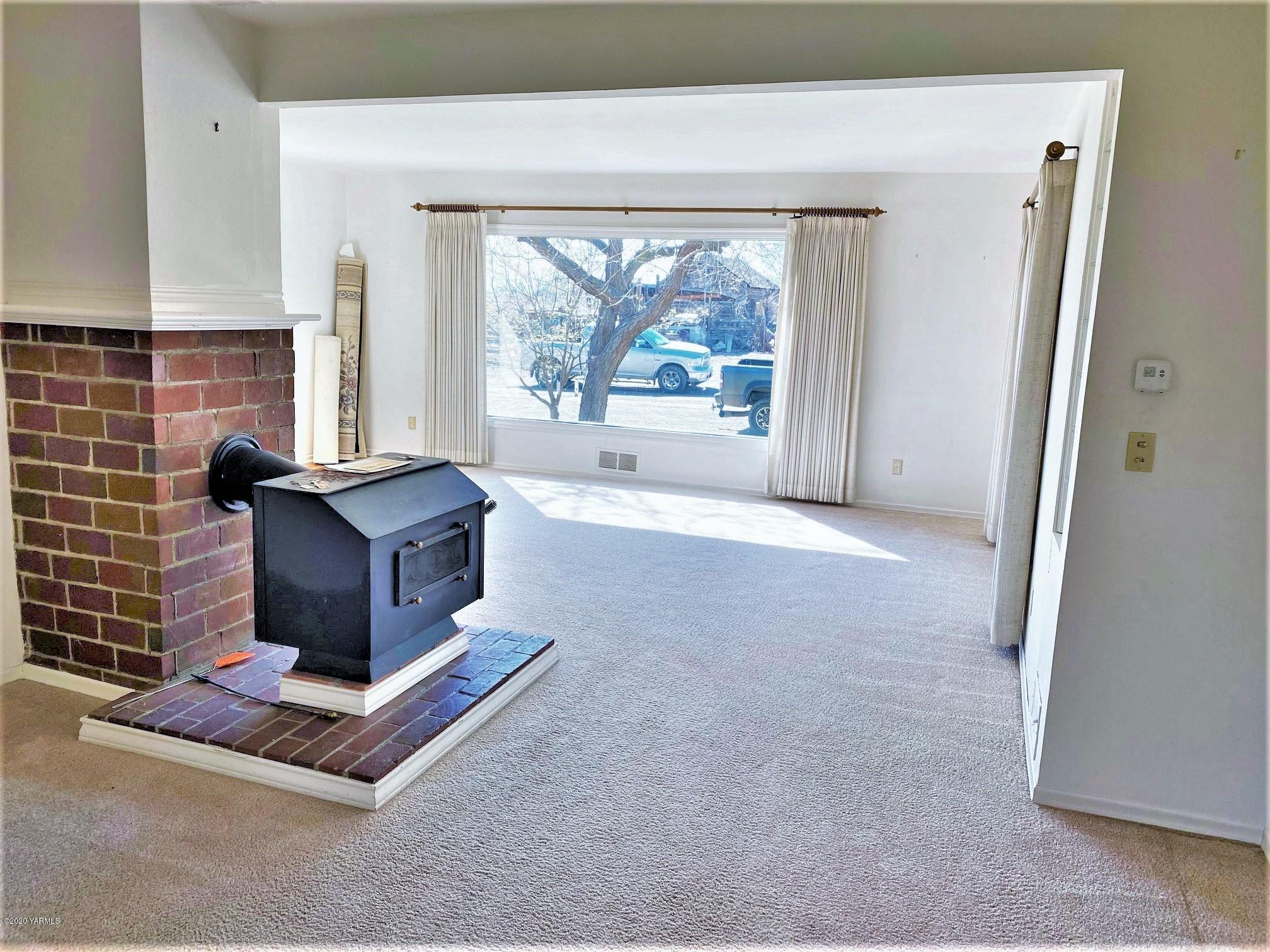 181 Wells Road Sunnyside, WA 98944 - Photo 3 of 25 a living room with furniture and a fireplace