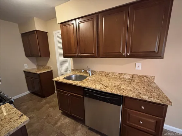 a kitchen with granite countertop wooden cabinets and a counter top space