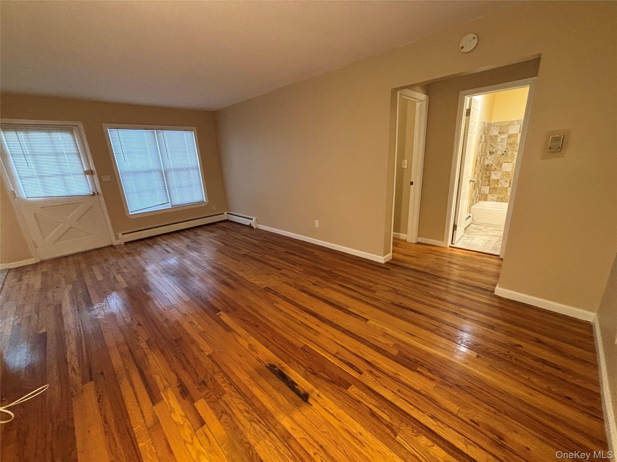 4 Colonial Road, Unit 92 Beacon, NY 12508 - Photo 6 of 9 a view of an empty room with wooden floor and window