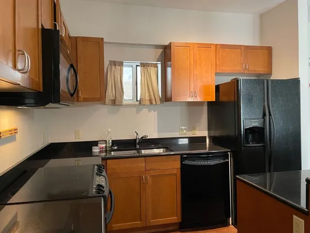 a kitchen with a sink a refrigerator and cabinets
