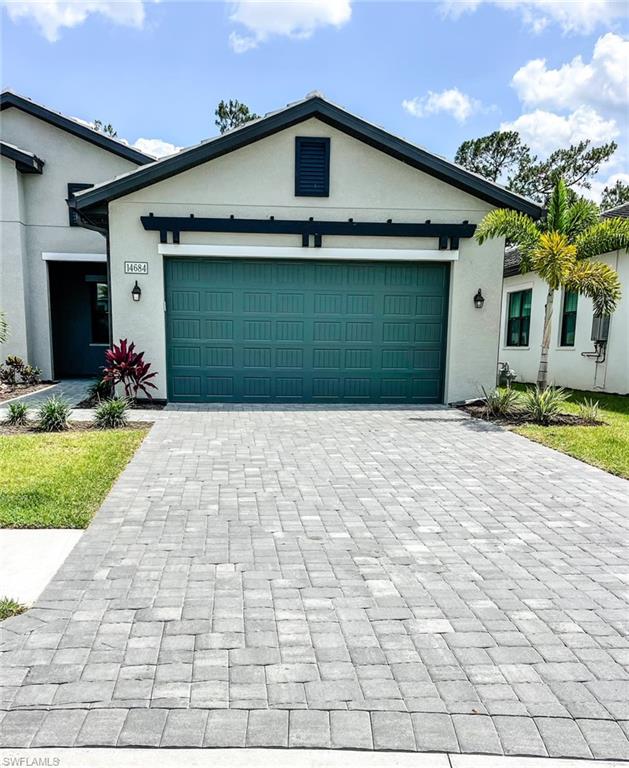 14684 Kingfisher Loop Naples, FL 34120 - Photo 5 of 18 a front view of a house with a yard and garage