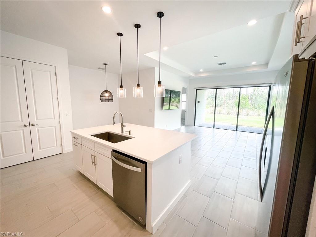 14684 Kingfisher Loop Naples, FL 34120 - Photo 6 of 18 a kitchen with a sink a stove a refrigerator and window