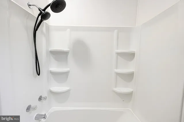 a bathroom with a shower a toilet and a window