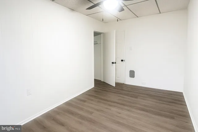 a view of an empty room with wooden floor