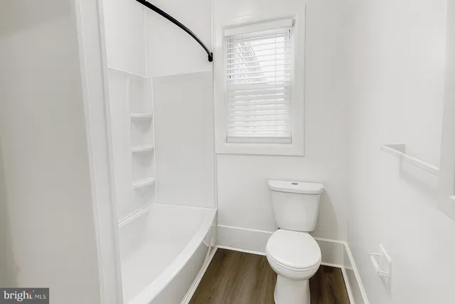 a white toilet sitting next to a window