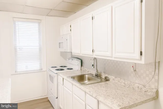 a kitchen with a sink cabinets and window