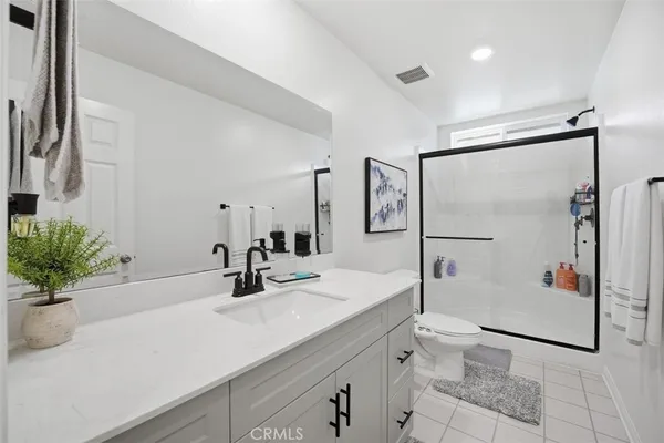 a bathroom with a shower sink mirror and toilet