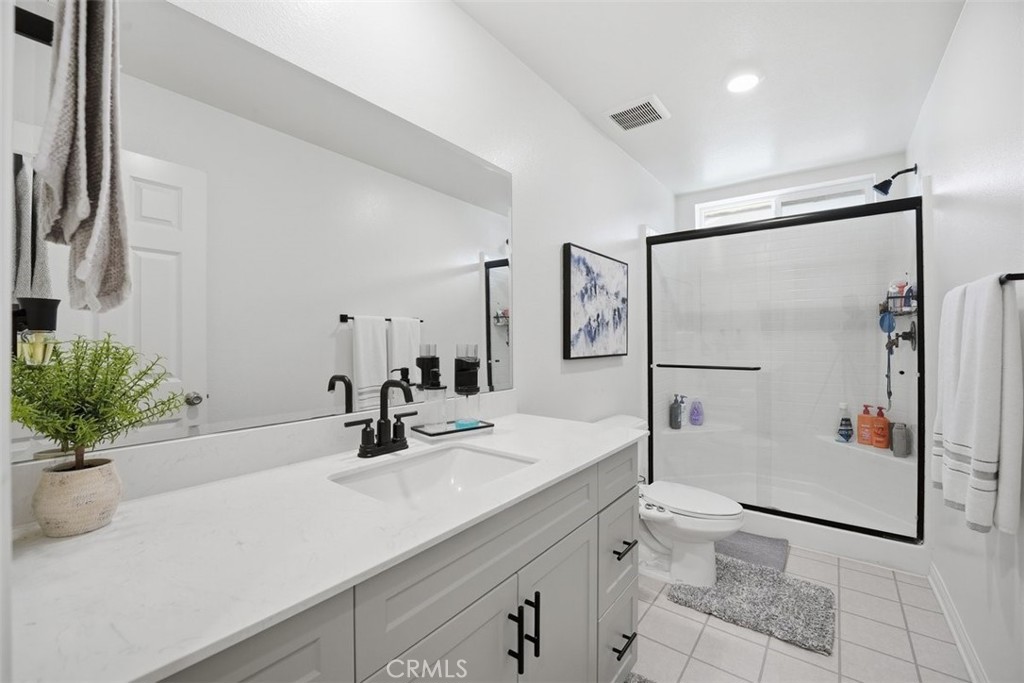 7608 Citrusmoon Court Riverside, CA 92507 - Photo 16 of 25 a bathroom with a shower sink mirror and toilet