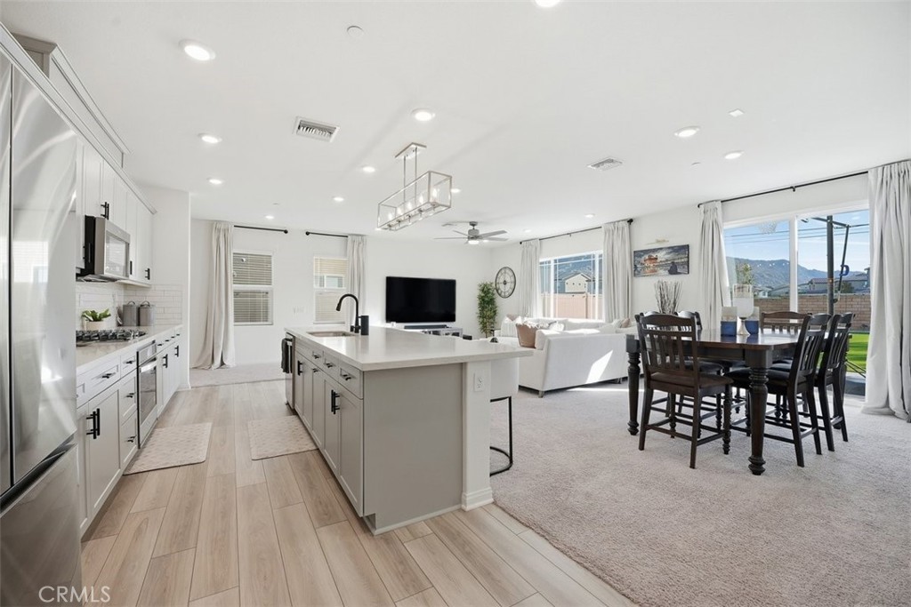 7608 Citrusmoon Court Riverside, CA 92507 - Photo 3 of 25 a large white kitchen with lots of counter space and furniture