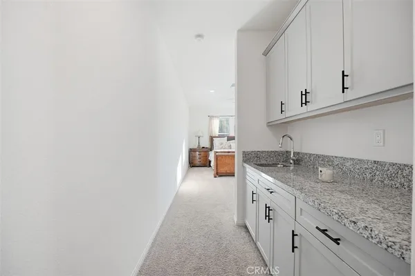 a kitchen with granite countertop white cabinets and sink