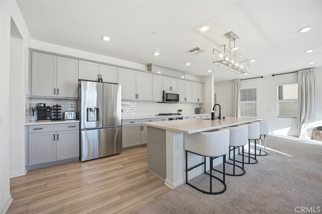 7608 Citrusmoon Court Riverside, CA 92507 - Photo 7 of 25 Abundance of cabinetry with upgraded backsplash. Elongated countertop for cooking prep, dining and extra seating.