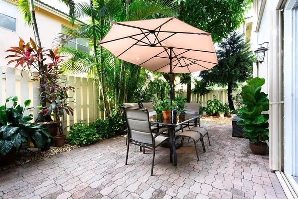 a view of a patio with table and chairs under an umbrella