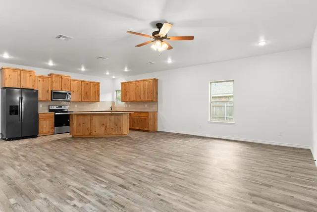 a view of kitchen with granite countertop cabinets and refrigerator