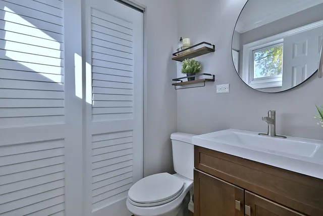 a bathroom with a toilet a sink and mirror