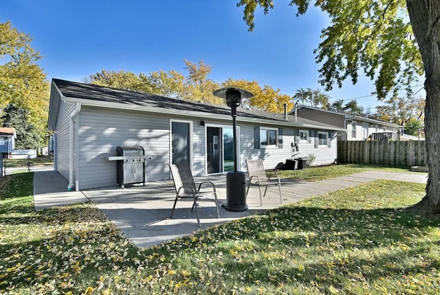 a view of a house with backyard and a tree