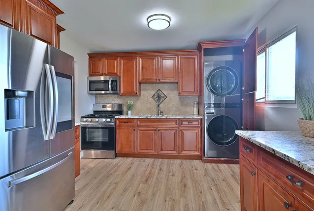 a kitchen with wooden cabinets and stainless steel appliances