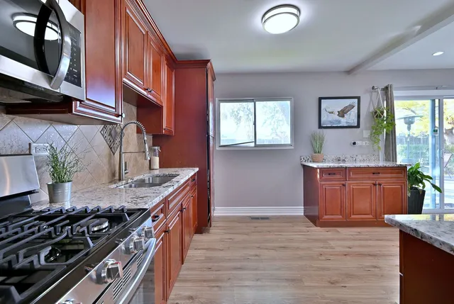 a kitchen with granite countertop a stove and a sink