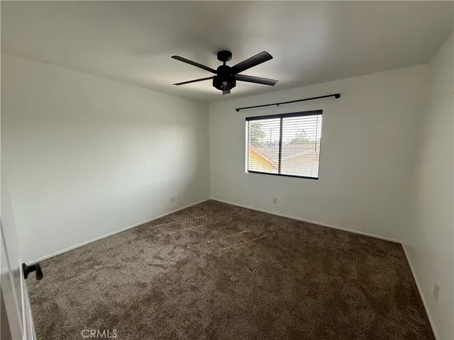 a bedroom with a bed a flat screen tv and windows