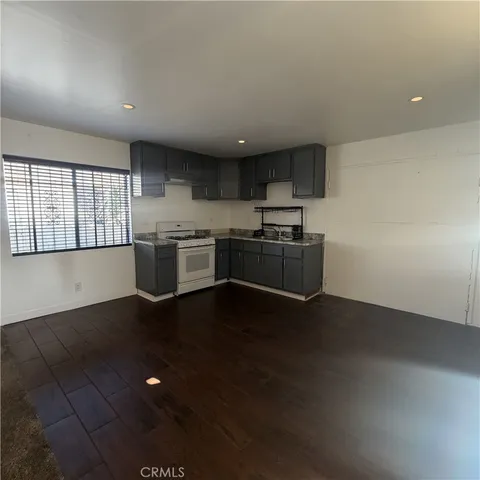 an empty room with kitchen view and a stove