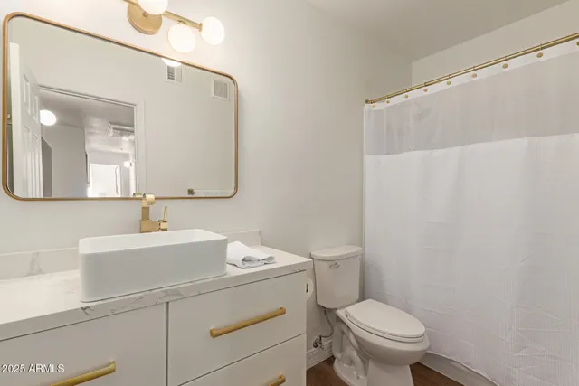 a bathroom with a sink a toilet and mirror