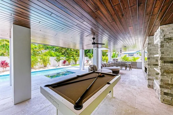 a room with pool table and windows