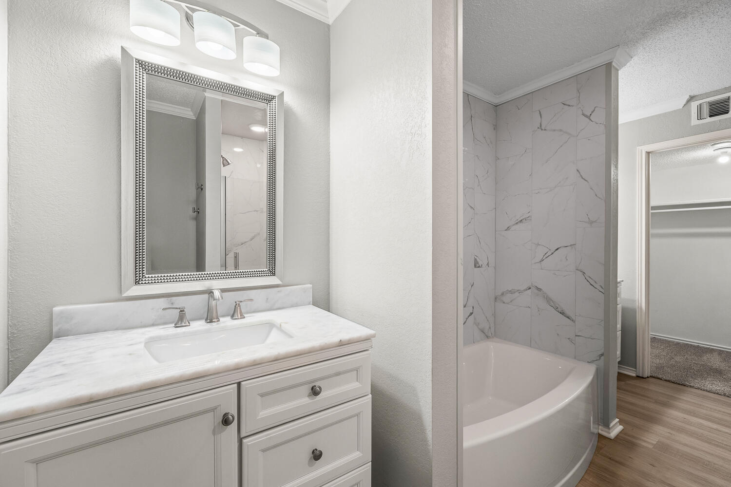 2302 Slide Road, Unit 35 Lubbock, TX 79407 - Photo 21 of 43 a bathroom with a bathtub a sink a vanity and a shower