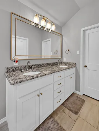 a bathroom with a granite countertop sink double and mirror