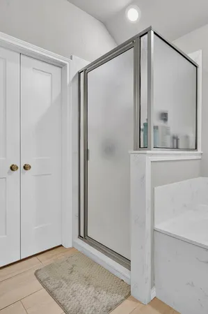 a view of an empty room with mirror and door