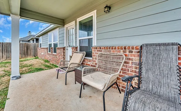a view of a patio with table and chairs with wooden floor and fence