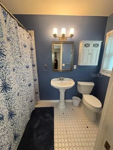 a bathroom with a sink toilet and a mirror