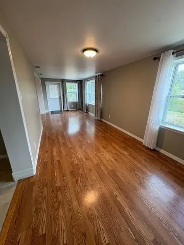 wooden floor in an empty room with a window