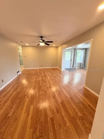 a view of empty room with wooden floor