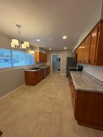 a view of a kitchen with a sink and dishwasher wooden floor