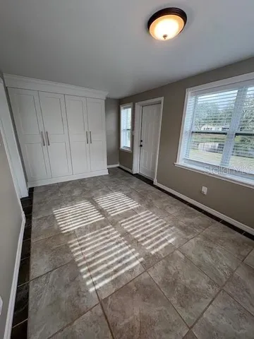 a view of an empty room with a cabinet and a window
