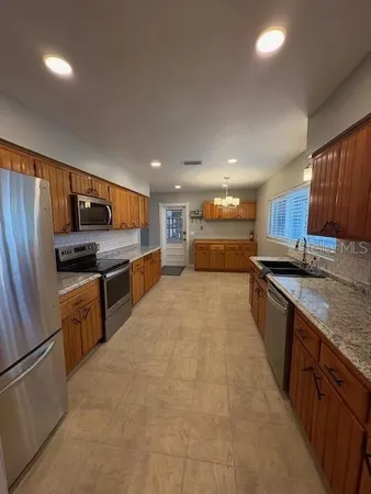 a large kitchen with a large counter top appliances and cabinets